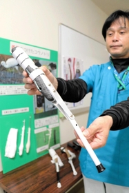 片足を失ったコウノトリに着けた義足を持つ獣医師の松本令以さん＝県立コウノトリの郷公園