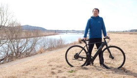 新発売した電動アシスト自転車と、開発を担当した惣塚利郎さん＝加古川市内（ムサシ提供）