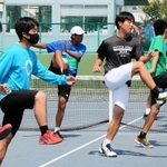 練習前の準備は入念だ。股関節をやわらかくする体操をこなす部員たち＝トップランテニスカレッジ石守校