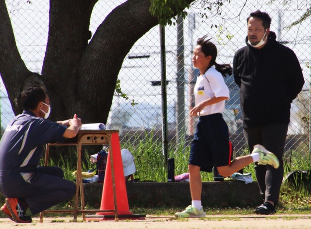 陸上競技部員を指導する石井洋之監督（右）＝稲美町岡