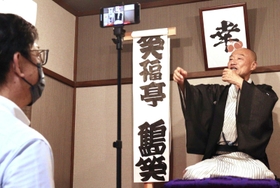「おでん工房　あんず庵」の寄席小屋で啓発動画を撮影する加西署の鈴木義則交通課長（左）と笑福亭鶴笑さん＝加古川市平岡町新在家