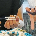 指で輪っかを編み込んでいく＝高砂市高砂町鍛冶屋町