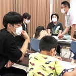 宿題を教えるボランティアと、熱心に宿題に取り組む児童＝平岡公民館