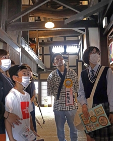 参加者とともにボランティアガイドの説明を受ける吉田裕さん（中央）＝工楽松右衛門旧宅