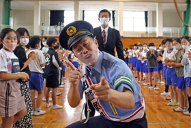 一日高砂警察署長として、母校の児童に迎えられる吉田裕さん＝米田小学校