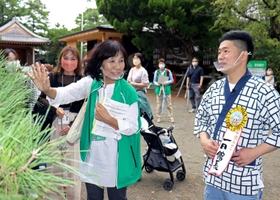 参加者とともにボランティアガイドの説明を受ける吉田裕さん＝高砂神社