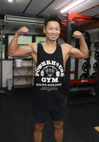 自慢の体をアピールする古市卓也さん＝加古川市加古川町北在家、シナジム加古川北在家店