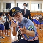 一日高砂警察署長として、母校の児童に迎えられる吉田裕さん＝米田小学校