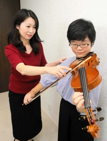 嶽崎あき子さん（左）の指導を受けて練習する中尾華さん＝加古川市