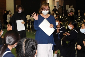 生徒に拍手で迎えられる「花＊花」のこじまいづみさん（中央）とおのまきこさん（左）＝加古川市平荘町山角、両荘中学校