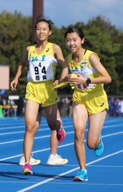 女子・稲美の４区長野紗弥選手（左）からたすきを受け取る５区湊友希選手＝加古川運動公園陸上競技場