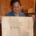 １１４年前に本紙が発行した地図を見る船倉光昭さん＝加古川市