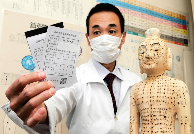 施術費助成制度の利用券を手に、存続を求める戸川真尚さん＝高砂市荒井町扇町