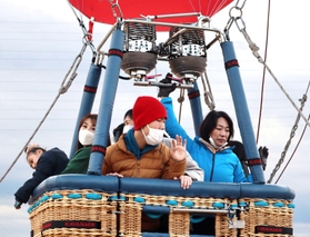 初めての気球での飛行体験に歓声をあげる参加者ら＝加古川市東神吉町砂部、東神吉南小学校