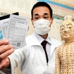 施術費助成制度の利用券を手に、存続を求める戸川真尚さん＝高砂市荒井町扇町