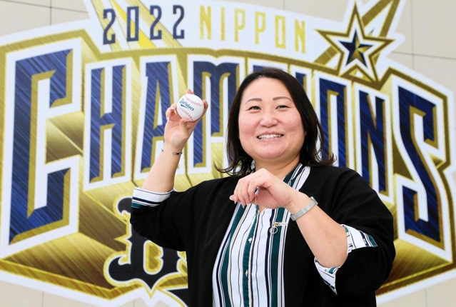オリックスの日本一を祝う看板前でボールを構える乾絵美さん。ソフトボールの現役時代は捕手として活躍した＝大阪市西区千代崎３、京セラドーム大阪