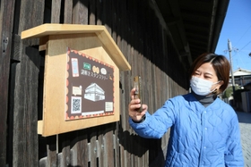 謎解きスタンプラリーの看板前でスマートフォンのアプリをかざすと、クイズに答えられる＝高砂市高砂町今津町、工楽松右衛門旧宅
