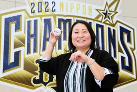 オリックスの日本一を祝う看板前でボールを構える乾絵美さん。ソフトボールの現役時代は捕手として活躍した＝大阪市西区千代崎３、京セラドーム大阪