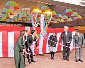 １５日にあったアンブレラスカイのお披露目式典で岡田康裕市長（左から３人目）らとくす玉を割る発案者の福田妃栞さん（右から３人目）＝かこてらす