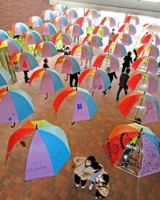 子どもの夢や願いが描かれたカラフルな傘が展示されている＝かこてらす