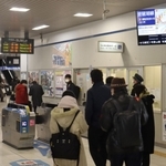 通勤や通学のため、駅の掲示板で運行状況を確認する人々＝２５日午前８時３２分