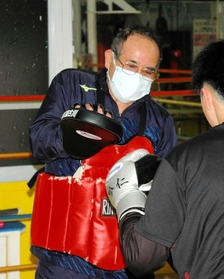 ７０歳を超えた今でも、若いボクサーのパンチを受ける熟山進之介会長（左）＝加古川市別府町朝日町