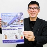 「加古川まつかぜハーフマラソン」のチラシを手に、笑顔を見せる神屋伸行さん＝加古川市加古川町粟津