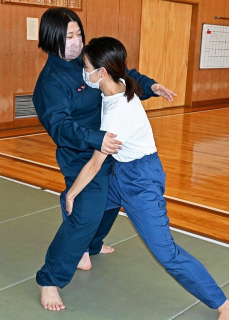 護身術ケース（２）「正面から殴られそうになったら」を女性署員に試みる記者（右）＝加古川署