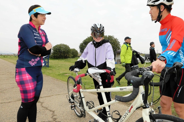弱視の中学生（左から２人目）に２人乗り自転車の乗り方を指導する円尾敦子さん（左端）＝加古川市加古川町、加古川河川敷