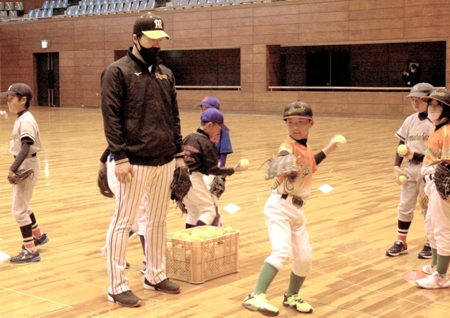 子どもたちの投球フォームを確認し、指導する元阪神の伊藤和雄さん＝高砂市総合体育館