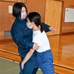 護身術ケース（２）「正面から殴られそうになったら」を女性署員に試みる記者（右）＝加古川署
