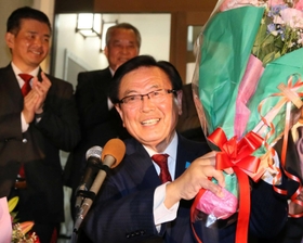 ８選を決めて、贈られた花束を手に笑顔を見せる山本敏信氏＝高砂市美保里