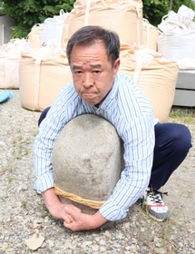 力石の奉納に挑む瀬川喜樹さん。石材業者に依頼して石を用意した＝高砂市阿弥陀町魚橋