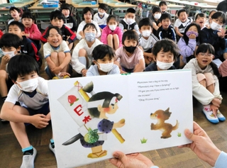 英語の絵本「桃太郎」の読み聞かせを楽しむ児童＝高砂市米田町米田、米田小