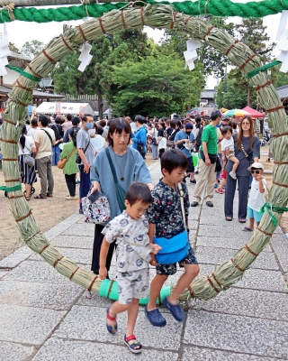 茅の輪をくぐる子どもたち＝日岡神社