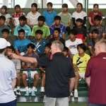 米国の大学コーチによるあいさつを聞く相生学院高校の選手たち＝三木市志染町三津田、ブルボンビーンズドーム