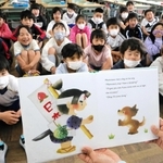 英語の絵本「桃太郎」の読み聞かせを楽しむ児童＝高砂市米田町米田、米田小