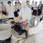 独自の料理論を伝えながら調理を進める奥田政行シェフ（手前右）。県農生が助手を務めた＝加古川市平岡町新在家