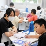 学生スタッフが子どもたちの宿題をお手伝い。多い日で子どもは４０人以上が集まるという＝加古川市平岡町新在家、兵庫大学