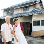 改築中の古民家前で笑顔を見せる工義尚さん（左）と妻の恵子さん＝加古川市志方町成井