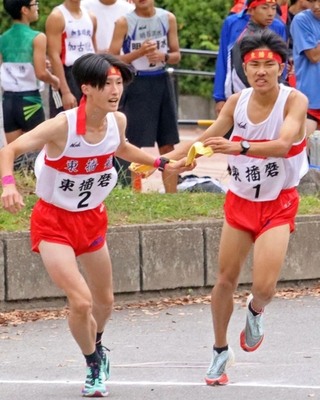 男子・東播磨１区貞平春陽選手（右）からたすきを託される２区高橋立輝選手＝西脇市総合市民センター
