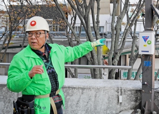 鳥が嫌がる高周波音を流す装置「バードソニック」を取り付ける岡山理科大教育推進機構の辻維周教授＝加古川市加古川町篠原町