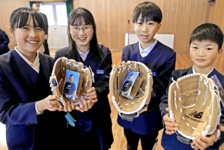 大谷選手から届いたグラブを手に笑顔を見せる児童ら＝母里小学校