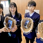 大谷選手から届いたグラブを手に笑顔を見せる児童ら＝母里小学校