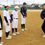 地域指導者から外野の捕球時の動きを教わる野球部の生徒たち＝陵南中学校