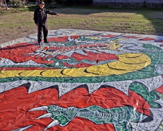 田畑に竜や恐竜などの巨大絵を描いた清水龍彦さん＝加古川市八幡町野村