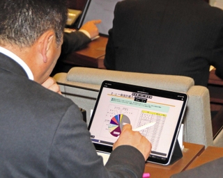 タブレット端末で資料を見る加古川市議＝同市議会議事堂