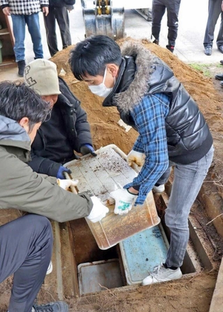 校庭に埋められたタイムカプセルを実行委員会のメンバーらが取り出した＝平荘小学校（実行委員会提供）