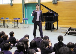 児童を前に伸びやかな歌声を披露する平松隆壱さん＝上荘小学校