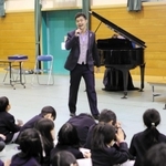 児童を前に伸びやかな歌声を披露する平松隆壱さん＝上荘小学校